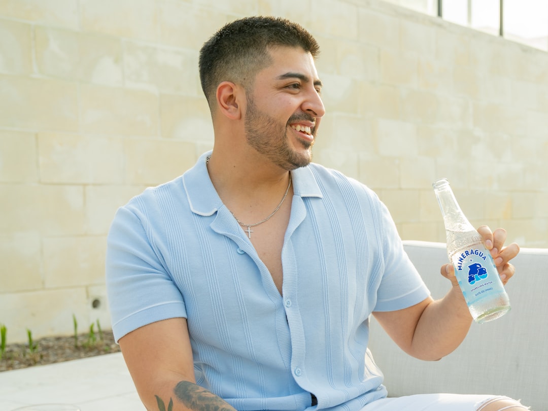 a man sitting on a couch holding a bottle of water