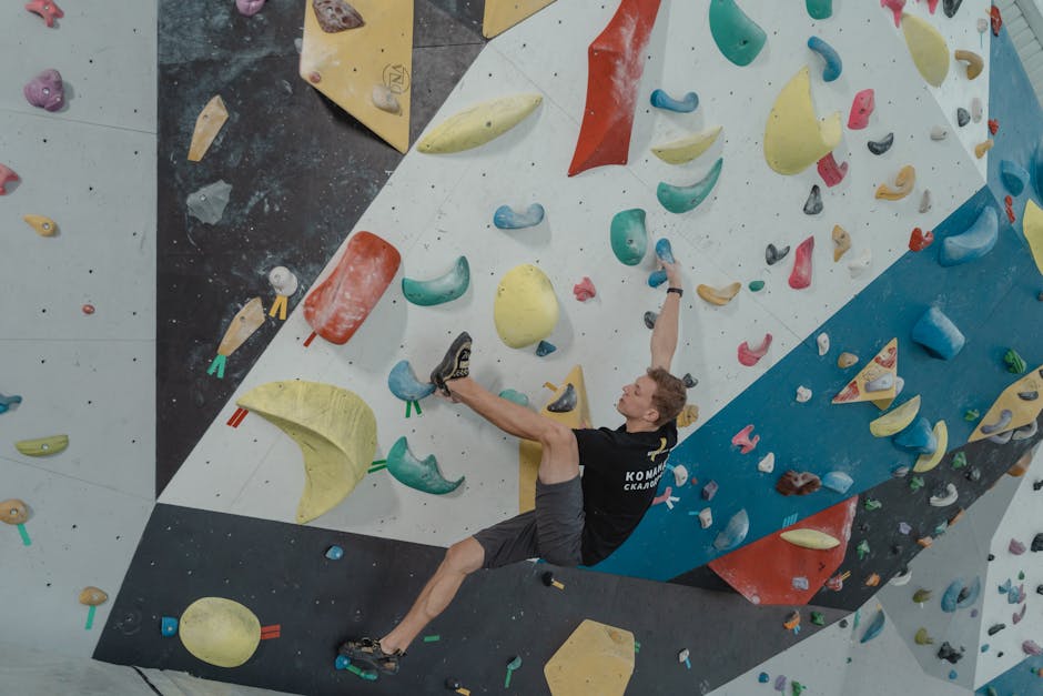 A dynamic shot of a person climbing a colorful indoor bouldering wall, showcasing strength and skill.