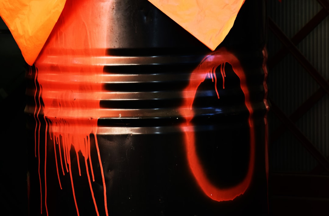 a black and orange trash can with a yellow umbrella