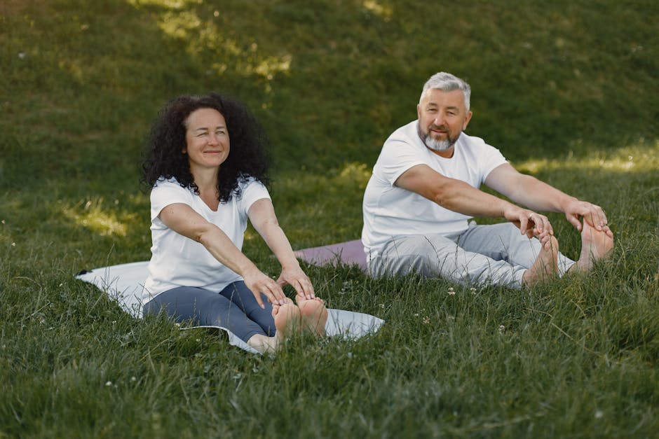 A mature couple enjoying a yoga session together outdoors on a sunny day.