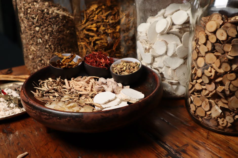 A collection of assorted traditional Chinese herbs and spices in jars and bowls.
