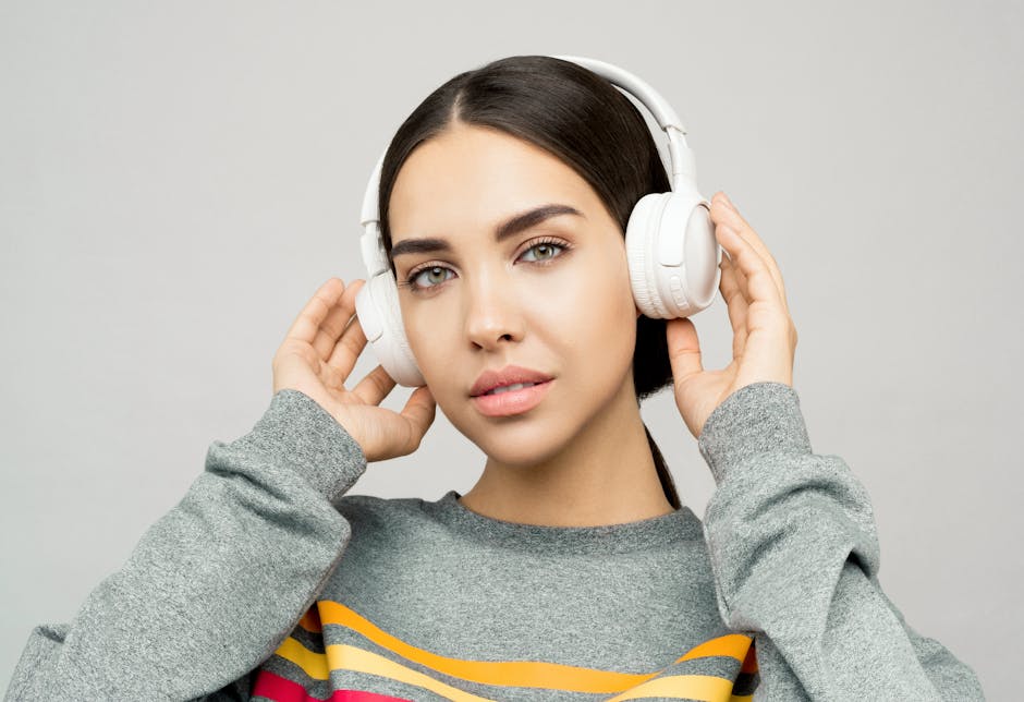 Portrait of a young woman wearing headphones, enjoying music indoors with a casual expression.