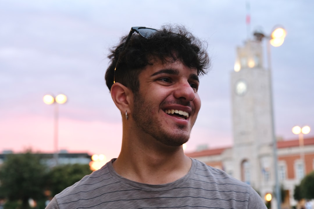 a man smiling with a tower in the background