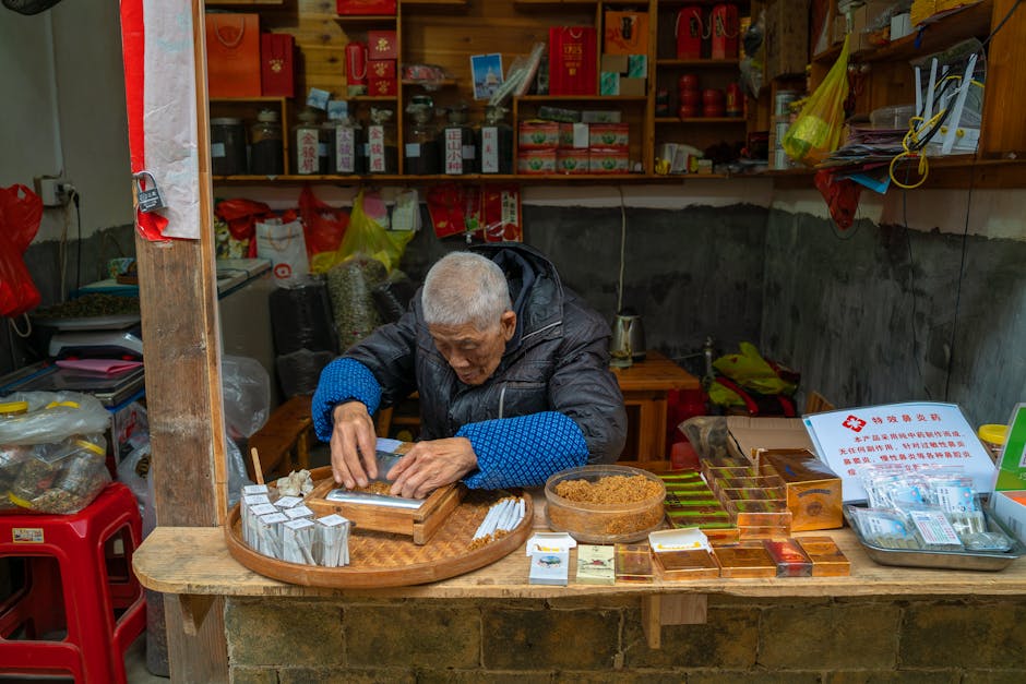 An elderly man prepares tea at a traditional shop in Xiamen, China, showcasing local culture and craftsmanship.