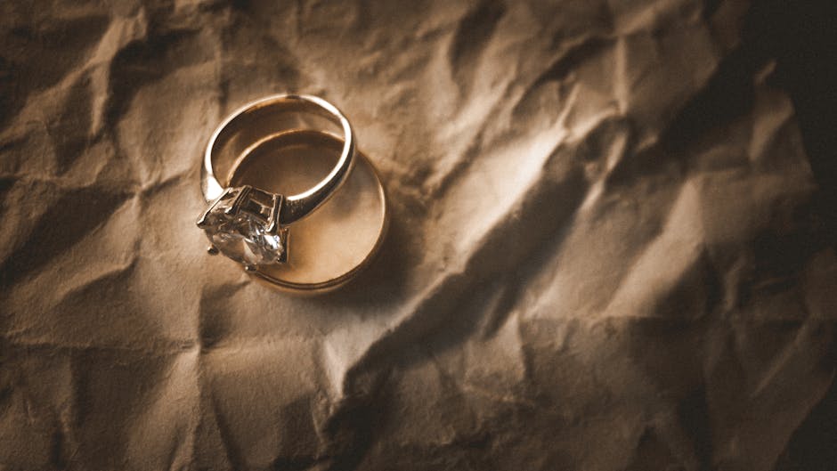 A refined shot of elegant gold and diamond wedding rings on wrinkled paper, showcasing luxury and commitment.